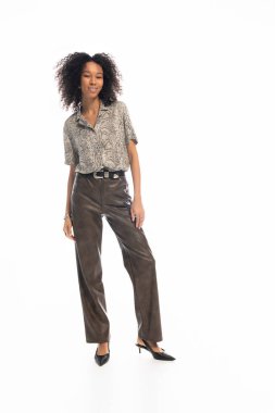 Genç ve güzel bir kadın şık bir görünüm sergiliyor, parlak bir ifadeyle zarif bir poz veriyor..