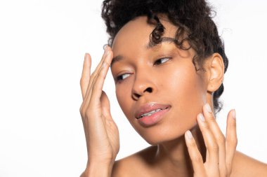 Yumuşak bir ışıkta, zarif genç bir kadın yanağını okşar, özgüven ve zarafeti somutlaştırır..