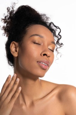 A stylish young woman with radiant skin experiences a tranquil moment, expressing beauty and grace.