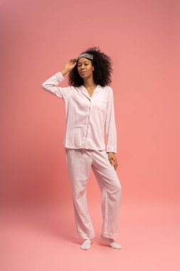 Genç, güzel bir kadın zarif bir şekilde rahat bir şekilde duruyor, büyüleyici ve kendine güvenen..