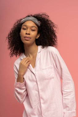 A beautiful young woman poses confidently in stylish sleepwear, radiating warmth and charm.