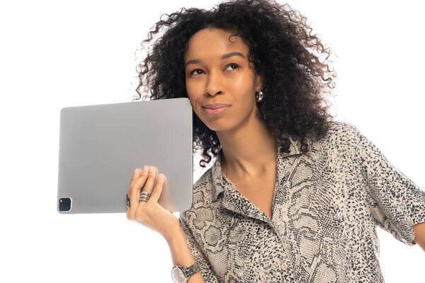 Красивая молодая женщина демонстрирует гладкий планшет, излучая уверенность и стиль.