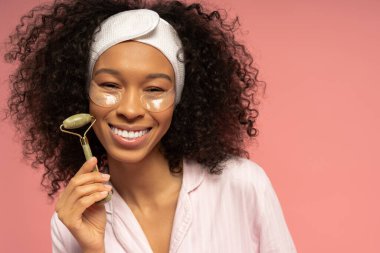 Şık bir kadın yeşil bir silindir ve göz bandı kullanır, göz alıcı güzellik ve güven saçar..