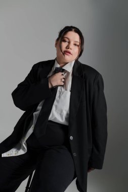 Güzel ve cüsseli bir kadın, eşsiz stilini sonsuz bir elbise içinde zarafet ve zarafetle sergiliyor..