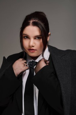 Cesur bir kıyafet içinde, şık ve iri yarı kadın özgüven ve duruş sergiliyor..