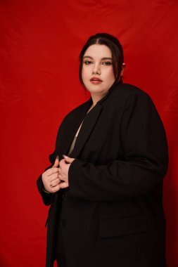 Kendine güveni tam, siyah takım elbiseli, modern moda ve güzelliğin vücut bulmuş hali..