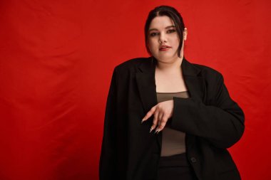 Güzel ve cüsseli bir kadın moda anlayışını neşeli bir poz ve şık bir kıyafetle sergiliyor..