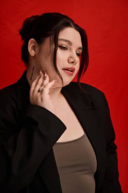 Kendine güvenen ve iri yarı bir kadın zarif bir şekilde poz verir..