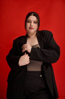 Güzel, iri yarı bir kadın şık moda seçimini sergilerken kendine güveni tam..