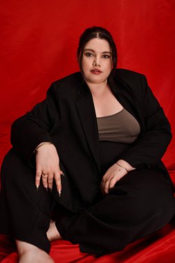 Çarpıcı, iri yarı bir kadın cesur bir ortamda rahatlar ve eşsiz tarzıyla hava atar..