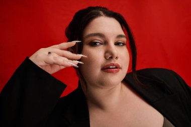 Kendine güveni tam ve cüsseli bir kadın şık bir elbise içinde zarif bir şekilde poz verir, güzelliğini ve tarzını ön plana çıkarır..