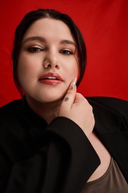 Güzel ve iri bir kadın zarif bir poz verirken eşsiz moda anlayışını sergiliyor..