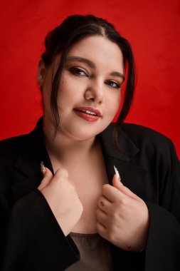 Bu güzel kadın zarif bir şekilde kırmızı arka planda moda anlayışını sergiliyor..