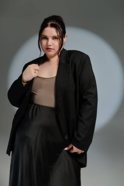 Şık, iri yarı bir kadın şık elbisesiyle zarafet saçar..