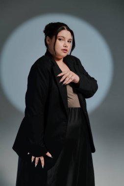 Çarpıcı ve cüsseli bir kadın şık bir kıyafete ve büyüleyici bir stile güvenir..