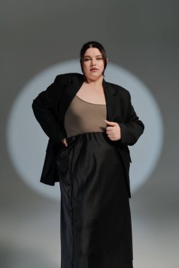 Güzel, iri yarı bir kadın entellektüel siyah elbisesiyle eşsiz moda anlayışını sergiliyor..