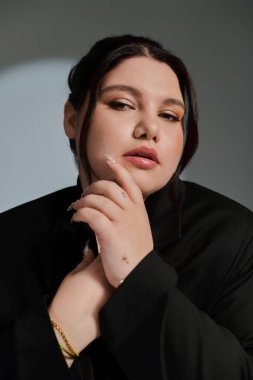Kendine güvenen ve cüsseli bir kadın şık görünümünü ve zarif makyajını sergiler..