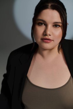 Güzel, iri yarı bir kadın şık moda anlayışını zarif bir stüdyoda sergiliyor..