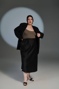 Güzel ve iri yarı bir kadın, kendine güvenen bir şekilde modellik yapıyor..