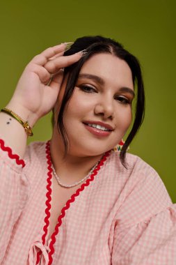 Parlak giyimli kadın tarzını ve özgüvenini sergiliyor. Ilık bir gülümsemeyle ışıldayan güzellik..