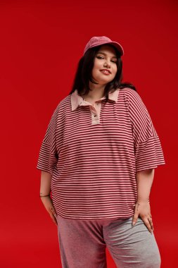 Güzel, iri yarı bir kadın kendine güvenen modaya uygun spor kıyafetlerinde kendine has tarzını sergiliyor..