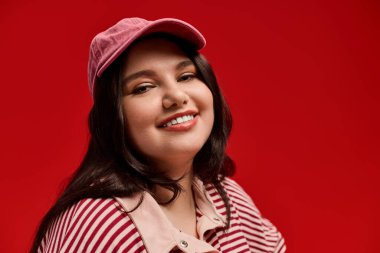 Güzel, iri yarı bir kadın zarif ve neşe dolu bir şekilde gülümseyerek moda anlayışını sergiliyor..