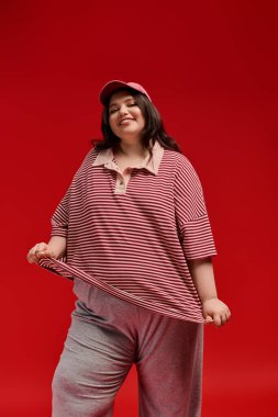 Artı cüsseli kadınlar moda anlayışını sergiliyor, şık çizgili kıyafetler giyiyor ve gülümsüyor..