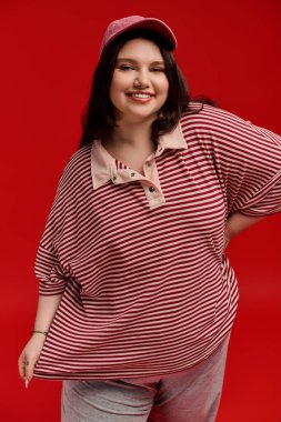 Kendine güveni tam, cüsseli bir kadın şık kıyafetiyle havalı bir şekilde gülümsüyor..