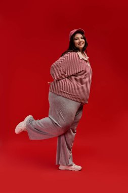 Kendine güveni tam, kilolu bir kadın, modaya uygun kıyafetlerini ve neşeli ruhunu sergiliyor..