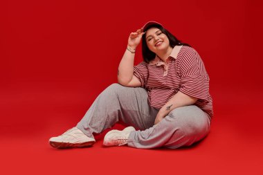 Kendine güvenen, güzel ve iri yarı bir kadın neşeli bir andan hoşlanıyor, sıradan giyinmiş..