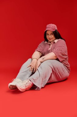 Kendine güveni tam ve cüsseli bir kadın, modaya uygun bir kıyafetle eşsiz tarzını sergiliyor..