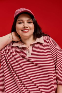 Kendine güvenen bir kadın şık çizgili bir elbiseyle poz verir..