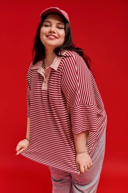 Büyük beden bir kadın şık, kalın çizgili bir elbiseyle ışıldıyor..