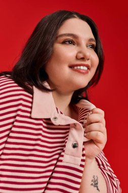 Havalı, iri yarı, neşeli gülüşlü bir kadın kendine güvenen eşsiz stilini vurguluyor..