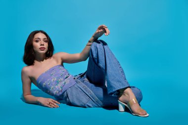 Şık genç bir kadın gevşetiyor, çağdaş modayı neşeli bir cazibeyle harmanlıyor..