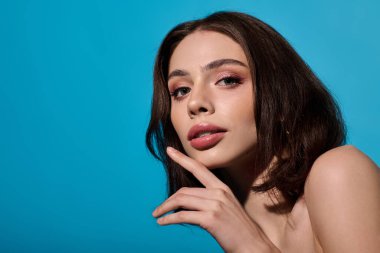 Güzel, genç bir kadın kendine güveni canlı bir mavi ile çevrili şık bir ifadeyle yayar..