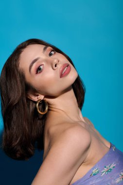 Şık bir genç kadın güzelliğini ve özgüvenini çarpıcı bir duruş ve makyajla sergiliyor..