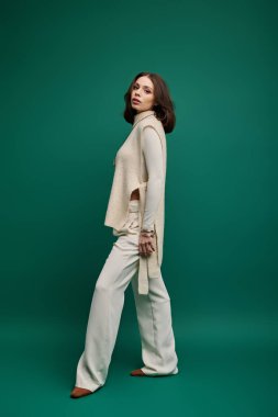 Zarif genç bir kadın şık bir elbise içinde kendine güvenerek poz verir. Moda anlayışı ve güzelliği yayar..