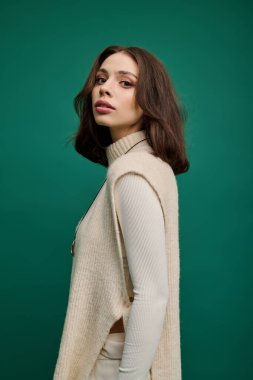 Kendine güvenen ve şık, genç bir kadın zarif ve zarif bir şekilde modern kıyafetlerini sergiliyor..