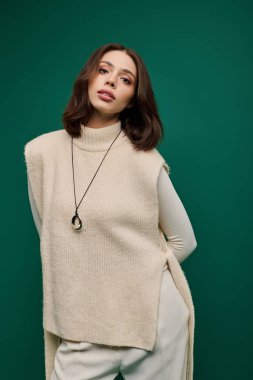 Güzel, genç bir kadın kendine güvenerek şık bir elbiseyle poz verir. Zarafet ve cazibe saçar..