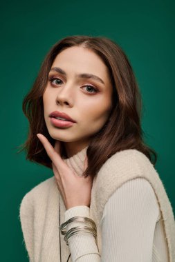 Şık genç kadın kendine güvenerek poz veriyor, şık elbisesini ve ışıl ışıl güzelliğini vurguluyor..