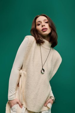 Modaya uygun genç bir kadın zarif bir şekilde poz verir, kendine has tarzını ve çekiciliğini ön plana çıkarır..