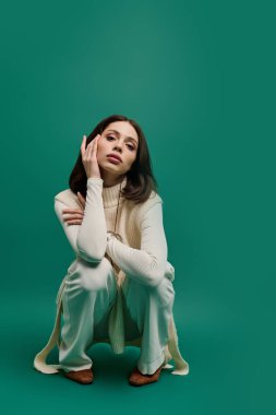 Güzel genç bir kadın moda kıyafetlerini sergiliyor, poz verirken özgüven ve zarafet saçıyor..