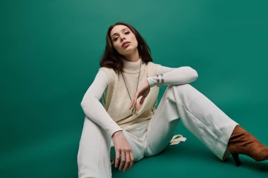 Genç bir kadın, benzersiz moda tarzını, zarif yeşil bir arka plana karşı sergiliyor..