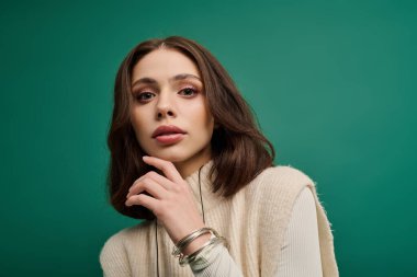 Şık bir genç kadın özgüven ve güzellik sergilerken modern kıyafetlerle düşünceli bir şekilde poz veriyor..