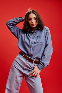 Genç, güzel bir kadın, sıradan bir kot giysisiyle poz verirken moda anlayışını sergiliyor..