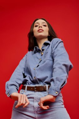 Güzel, genç bir kadın kotla şık bir şekilde poz veriyor, yaratıcılık ve zarafeti ifade ediyor..