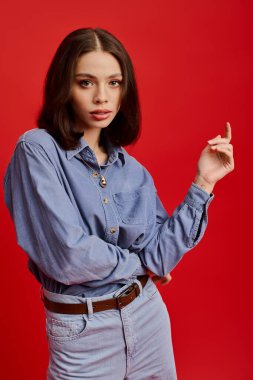 Kot gömlekli ve dar kotlu genç bir kadın şık bir poz veriyor..