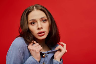 Modaya uygun genç bir kadın, güzelliğini ve tarzını ifade eden bakışları ve günlük kıyafetleriyle sergiliyor..