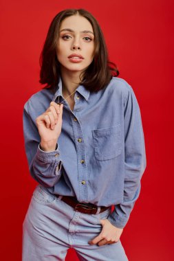 Şık bir kıyafet içinde, genç ve güzel bir kadın neşeli bir ifadeyle kendine güvenir..